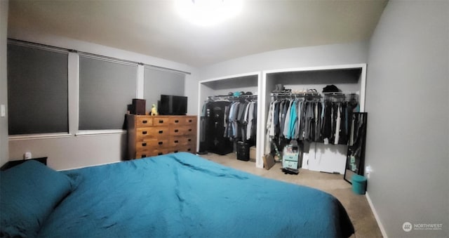 carpeted bedroom with multiple closets