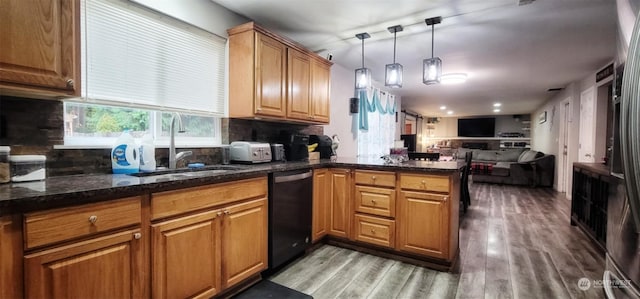 kitchen with decorative light fixtures, wood-type flooring, sink, decorative backsplash, and dark stone counters