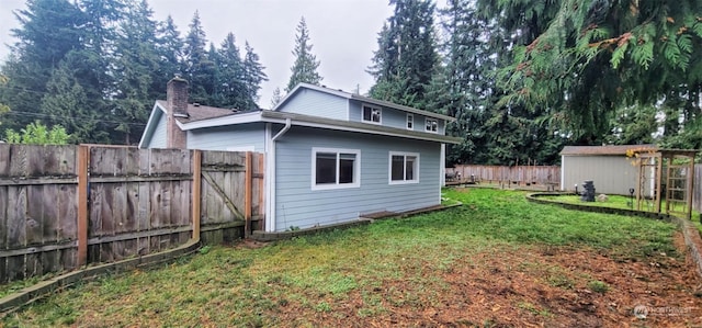 rear view of house featuring a yard and a storage shed