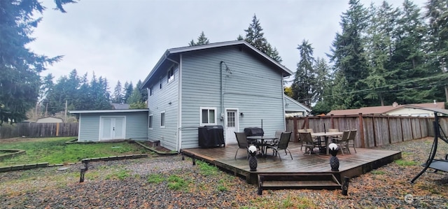 rear view of property with a lawn and a deck