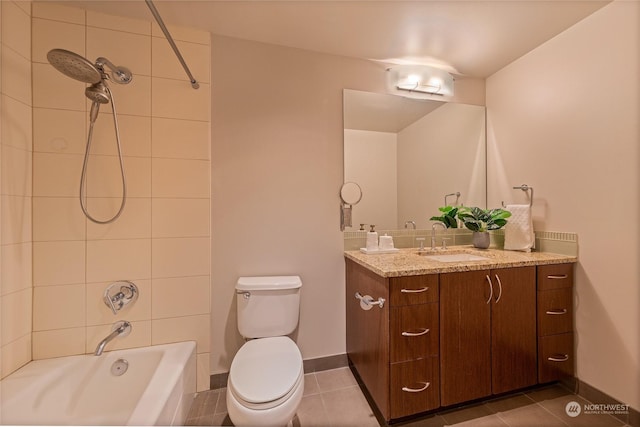 full bathroom featuring vanity, tiled shower / bath, tile patterned floors, and toilet