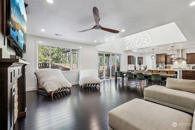 living room with dark wood-type flooring, a fireplace, and ceiling fan