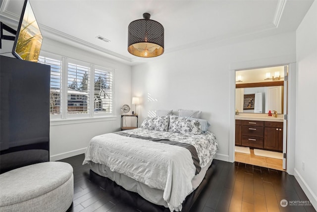 bedroom with ensuite bath, a tray ceiling, dark hardwood / wood-style flooring, and sink