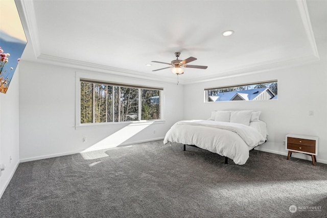 carpeted bedroom with ceiling fan, ornamental molding, and a raised ceiling