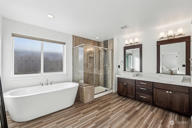 bathroom featuring vanity and independent shower and bath