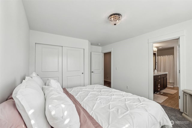 bedroom with ensuite bathroom, hardwood / wood-style floors, and a closet