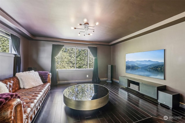 living room with plenty of natural light, dark hardwood / wood-style floors, and an inviting chandelier