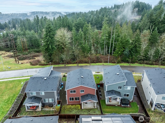 drone / aerial view featuring a wooded view