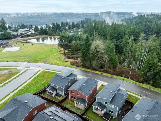 drone / aerial view with a water view and a forest view