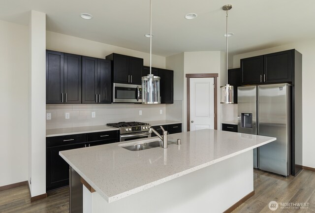 kitchen with stainless steel appliances, dark wood-style floors, and tasteful backsplash