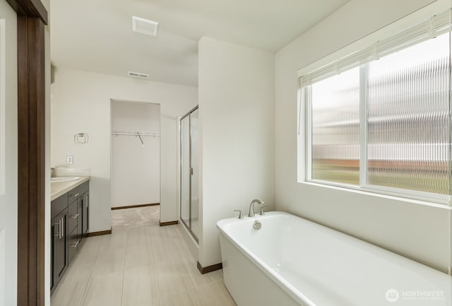 full bathroom with a freestanding bath, a shower stall, and visible vents