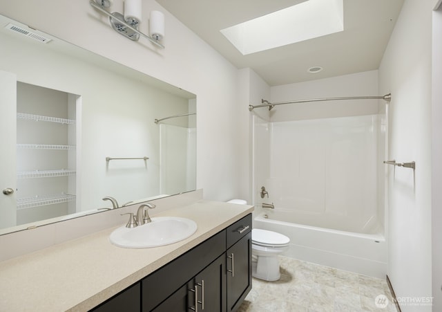 full bathroom with a skylight, visible vents, toilet, vanity, and shower / bathtub combination