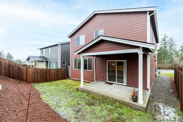 back of property featuring a fenced backyard, a patio, and a lawn