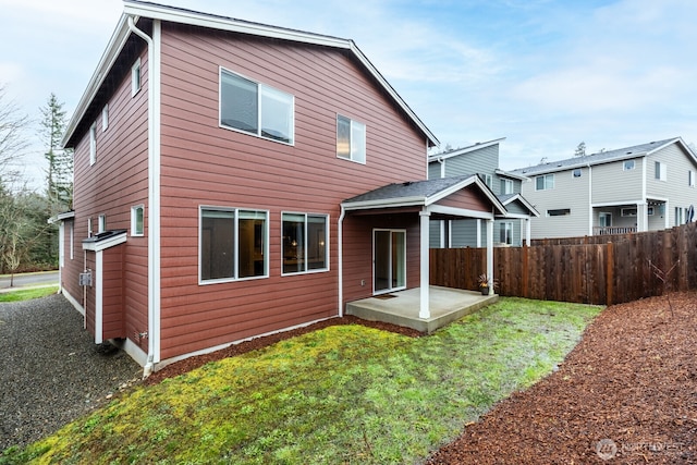 rear view of house with a yard, fence, and a patio