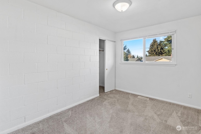 unfurnished bedroom with light carpet and a closet