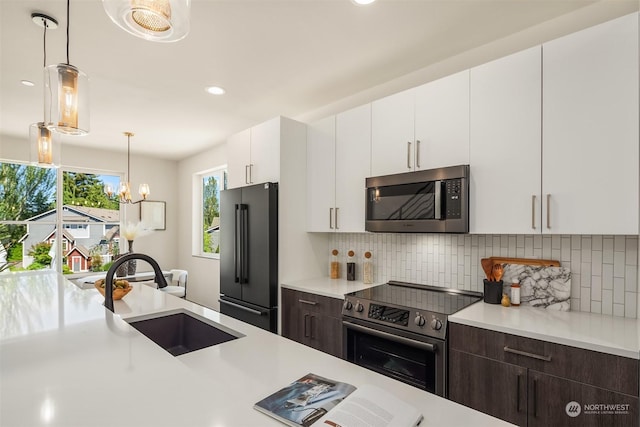 kitchen with dark brown cabinetry, sink, white cabinetry, and appliances with stainless steel finishes