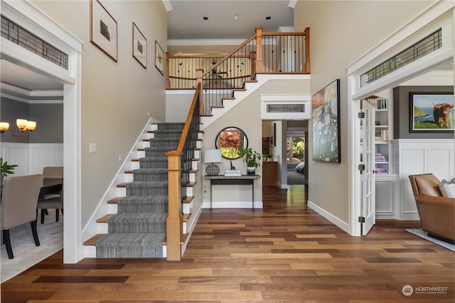 interior space with ornamental molding, wood-type flooring, and a notable chandelier