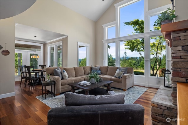 living room with a wealth of natural light, high vaulted ceiling, and dark hardwood / wood-style floors