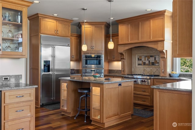 kitchen featuring tasteful backsplash, a center island, hanging light fixtures, dark hardwood / wood-style flooring, and stainless steel appliances