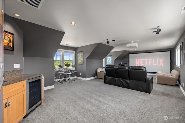 carpeted cinema with wine cooler and lofted ceiling