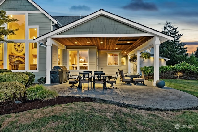 back house at dusk with a patio area