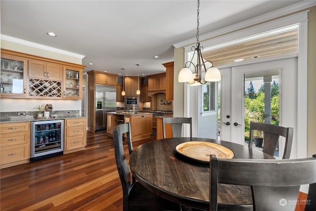 dining area featuring dark hardwood / wood-style floors, wine cooler, a notable chandelier, crown molding, and bar area