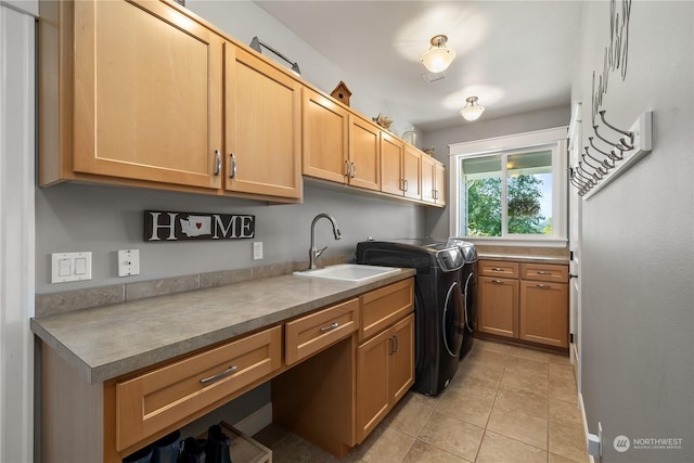 clothes washing area featuring cabinets, washer and clothes dryer, sink, and light tile patterned floors