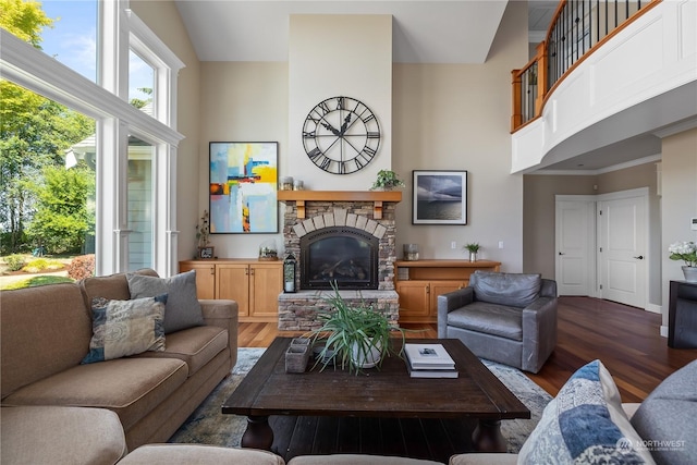 living room featuring hardwood / wood-style flooring, a high ceiling, and a fireplace