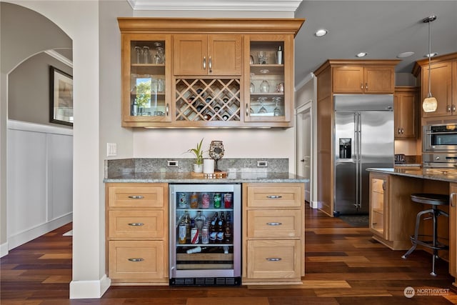 bar featuring stainless steel built in refrigerator, wine cooler, crown molding, and decorative light fixtures