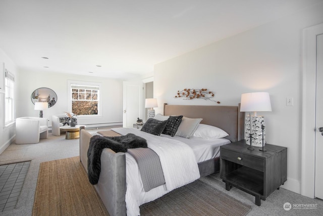 bedroom with multiple windows, a baseboard heating unit, and light carpet