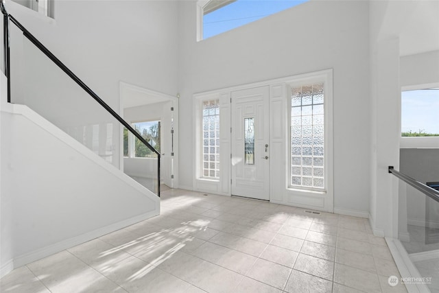 entrance foyer with a towering ceiling and light tile patterned flooring