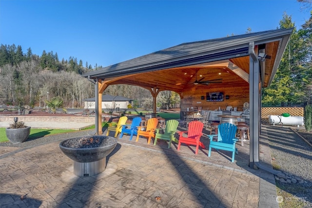 view of patio featuring ceiling fan and an outdoor fire pit