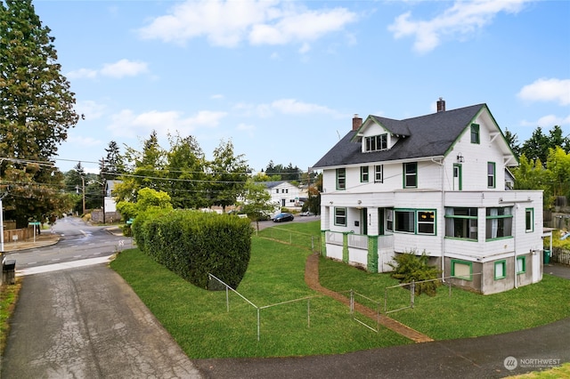 view of front of house featuring a chimney and a front lawn