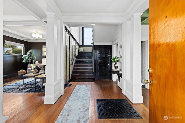 foyer entrance featuring stairway, crown molding, ornate columns, and hardwood / wood-style flooring