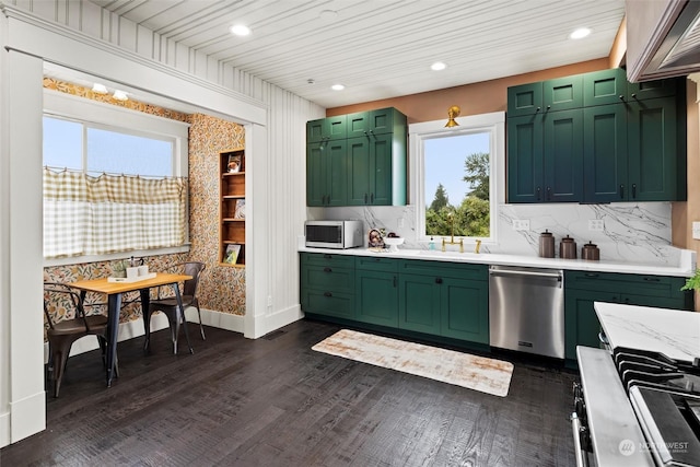 kitchen featuring a sink, stainless steel appliances, dark wood-type flooring, and green cabinets