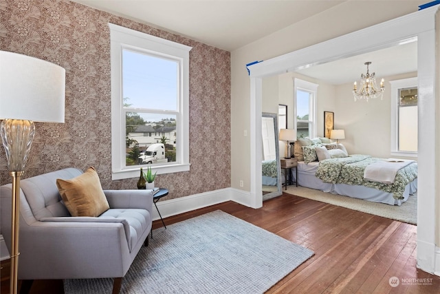 bedroom featuring hardwood / wood-style floors, a chandelier, and wallpapered walls