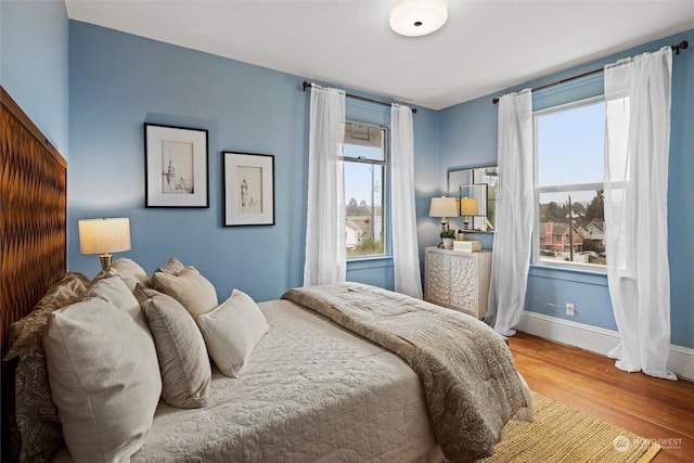 bedroom with baseboards and wood finished floors