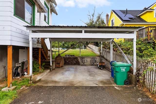 view of parking featuring stairs and fence