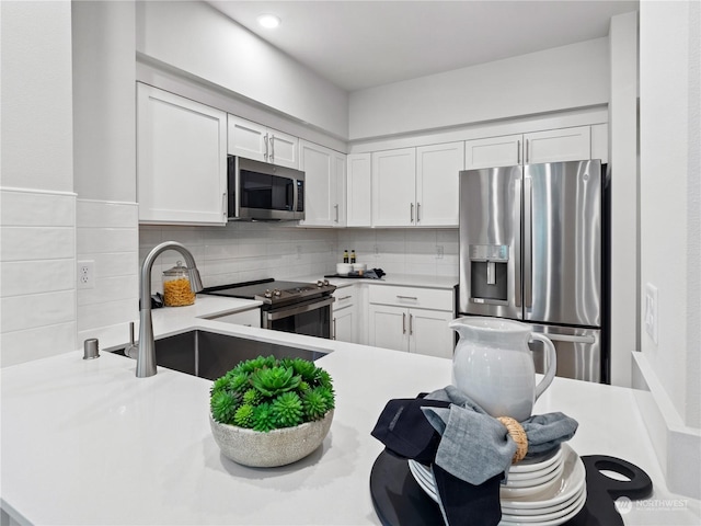 kitchen with stainless steel appliances, white cabinetry, sink, and decorative backsplash