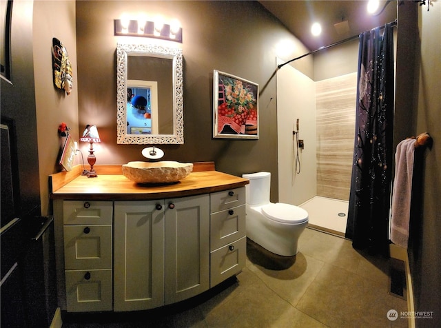 bathroom with vanity, curtained shower, tile patterned floors, and toilet