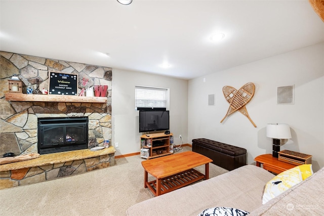 living room featuring a stone fireplace and carpet flooring