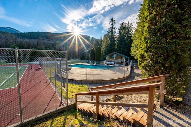 view of pool featuring a mountain view and tennis court