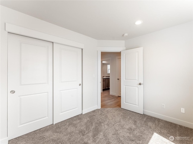 unfurnished bedroom with light carpet and a closet