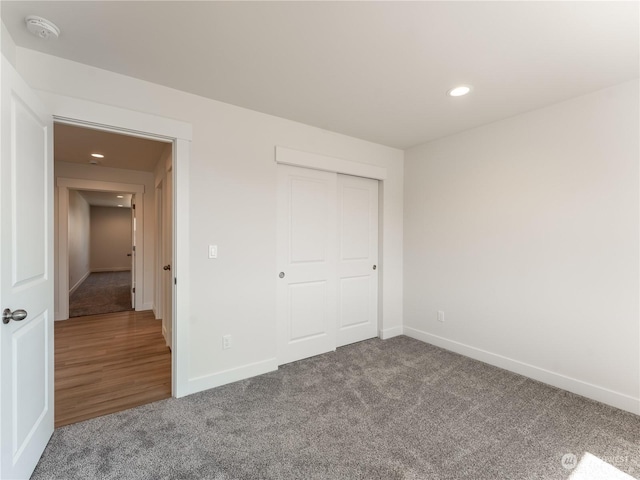 unfurnished bedroom featuring carpet flooring and a closet