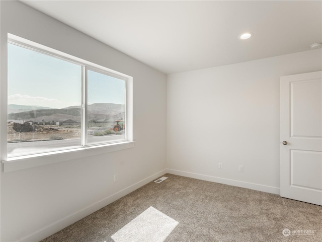 carpeted empty room featuring a mountain view