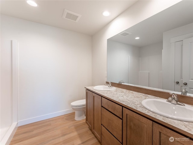 bathroom featuring wood-type flooring, toilet, and vanity