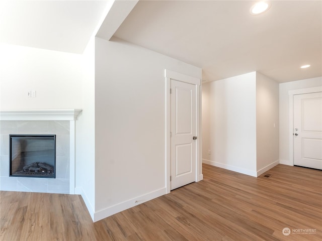 unfurnished living room with a fireplace and light wood-type flooring