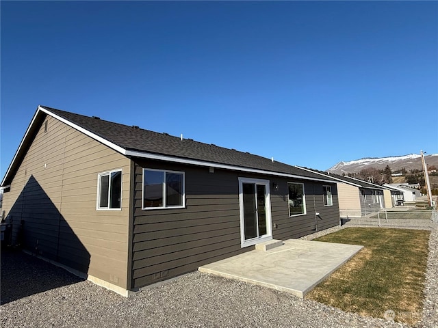 rear view of property featuring a mountain view and a patio area