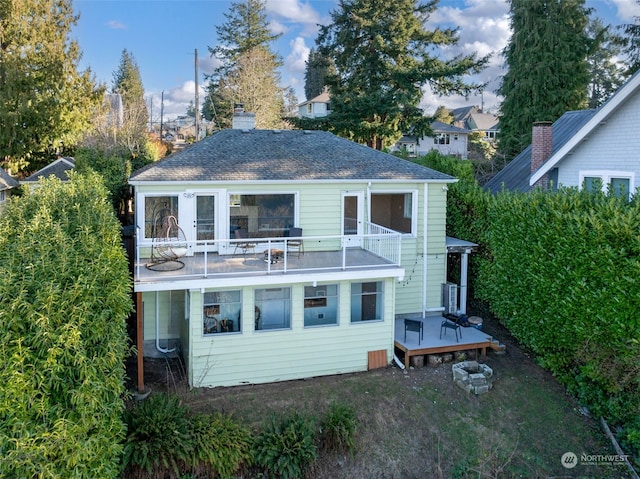 back of house with a wooden deck and a balcony