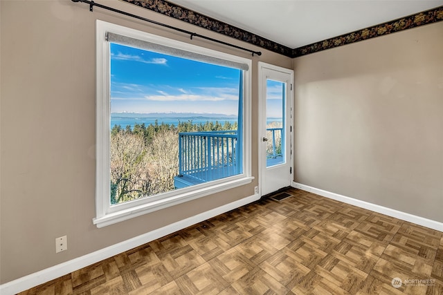 unfurnished room with a water view and parquet flooring